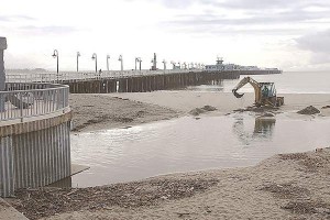 A backhoe loader is used to dig a channel from the Neary Lagoon Stormwater Outflow to the Monterey Bay at Cowell Beach last year. A working group studying contamination at Cowells considers the lagoon a potential source of bacteria. (Dan Coyro -- Santa Cruz Sentinel file)