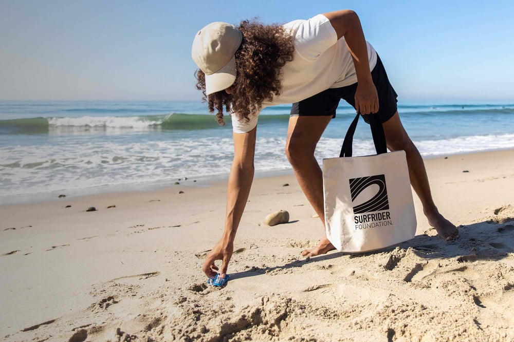 A volunteer picking up trash at the beach